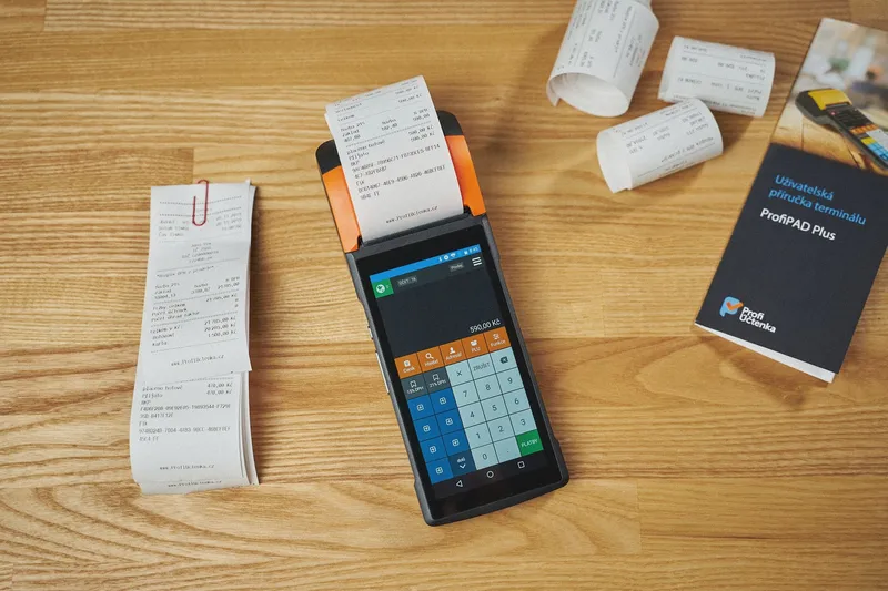 Handheld receipt printer and printed receipts on a wooden desk